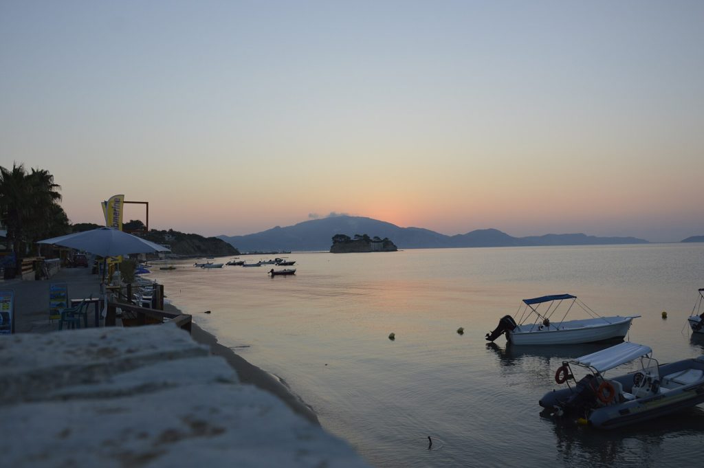 Ufer von Agios Sostis am Morgen mit kleinen Booten, im Hintergrund die Insel Cameo