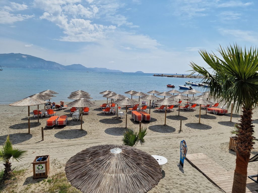 Strohschirme und Liegen am Sandstrand von Agios Sostis