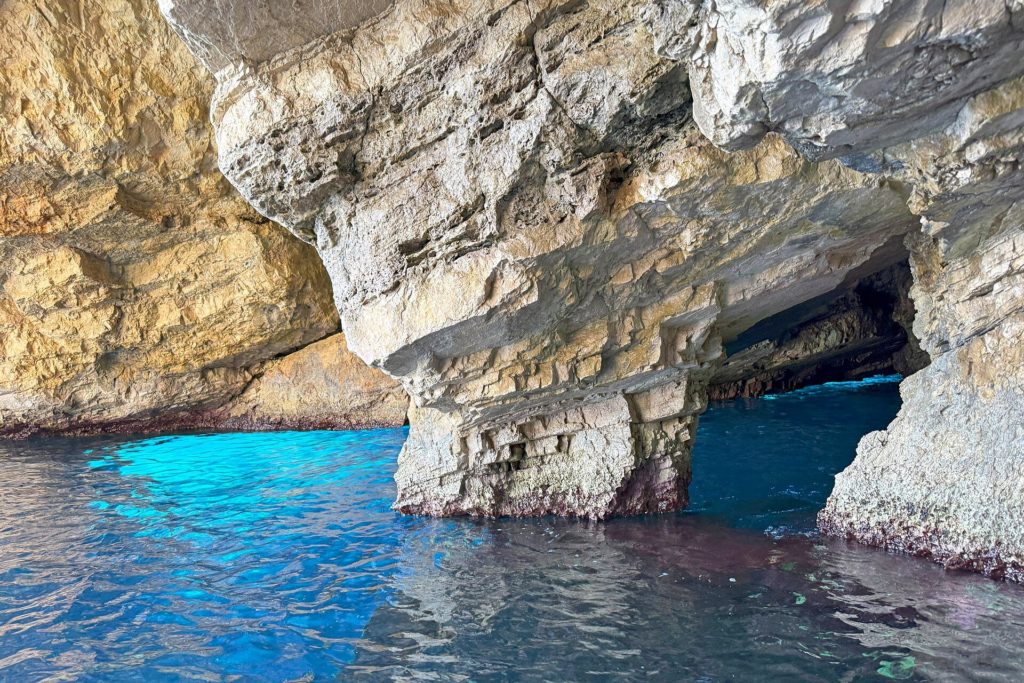 Weißer Kalkfelsbogen über leuchtend türkisblauem Wasser in den Blue Caves