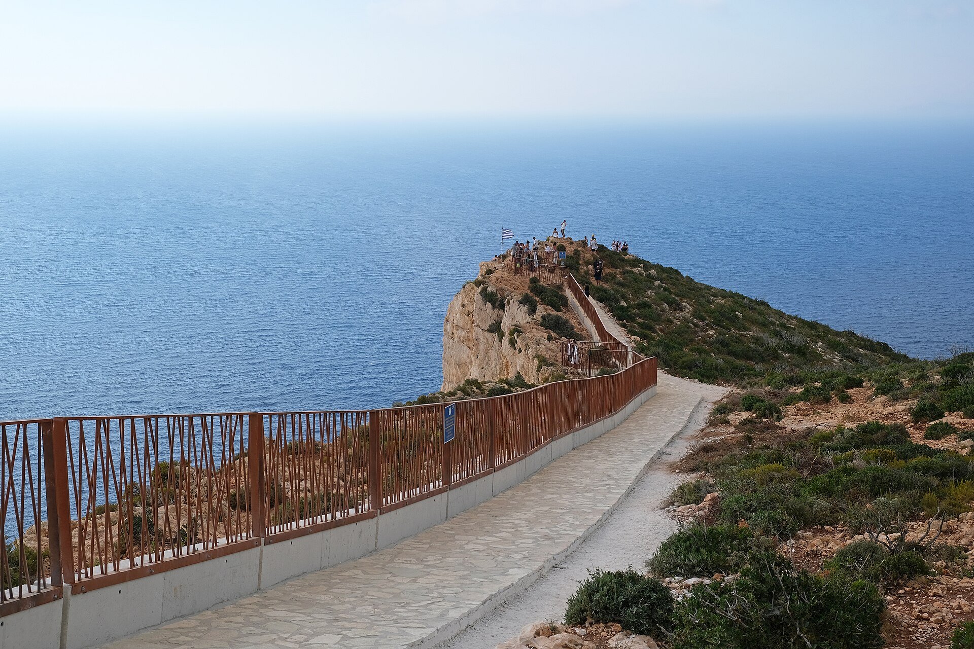 Gepflasterter Weg mit Geländer zur Aussichtsplattform hoch über dem Meer an der Navagio-Bucht