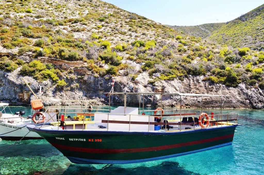 Ausflugsboot im türkisfarbenen Wasser vor der Küste