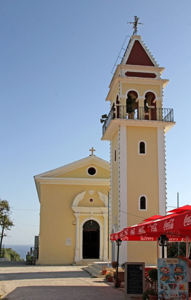 Gelbe Kirche mit hohem Glockenturm in Bochali unter blauem Himmel