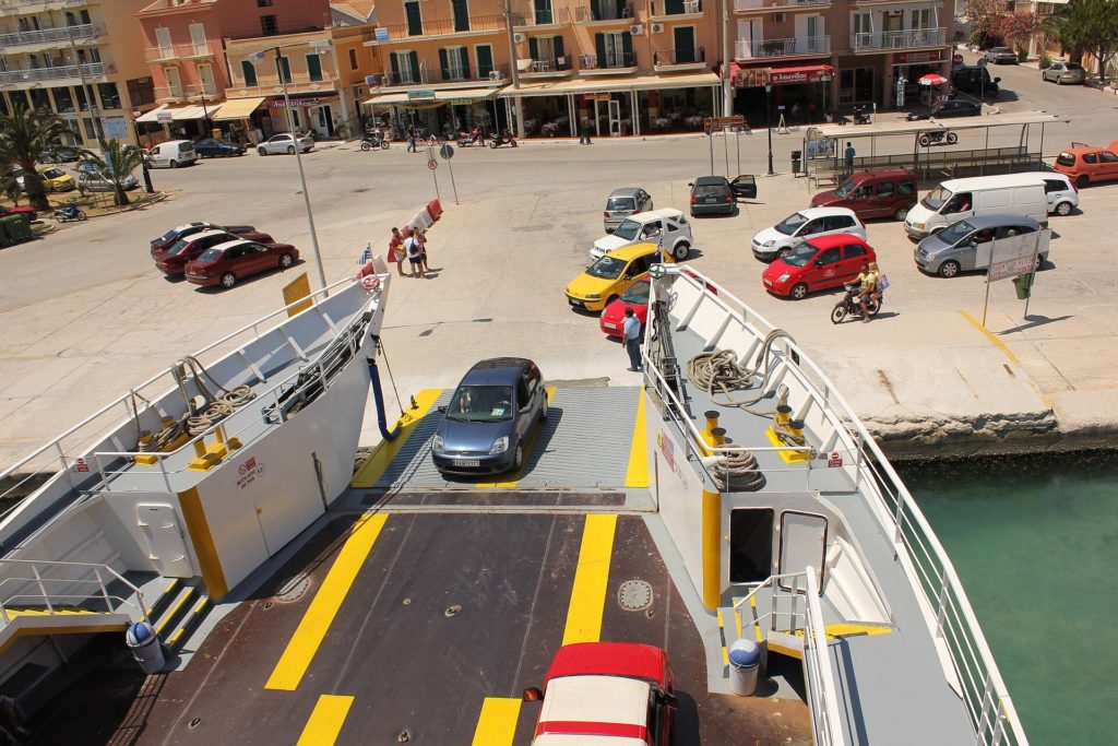 Autos fahren über die Rampe auf eine Fähre am Kai von Argostoli