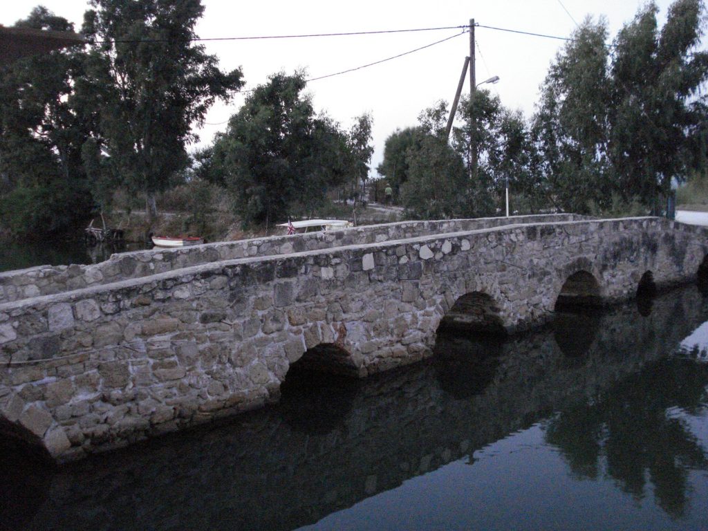Alte Steinbrücke mit mehreren Bögen über ruhigem Wasser