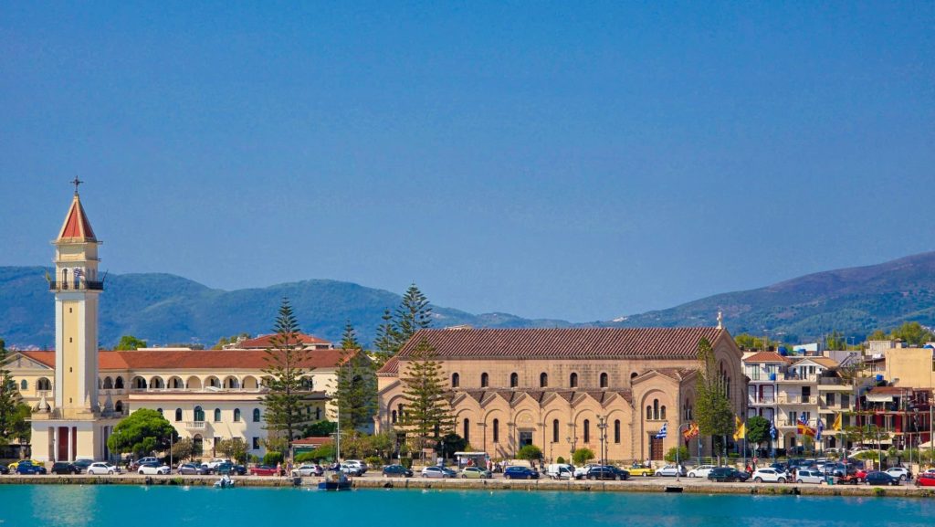 Kirche und Klostergebäude des Agios Dionysios mit Glockenturm, vom Wasser aus gesehen