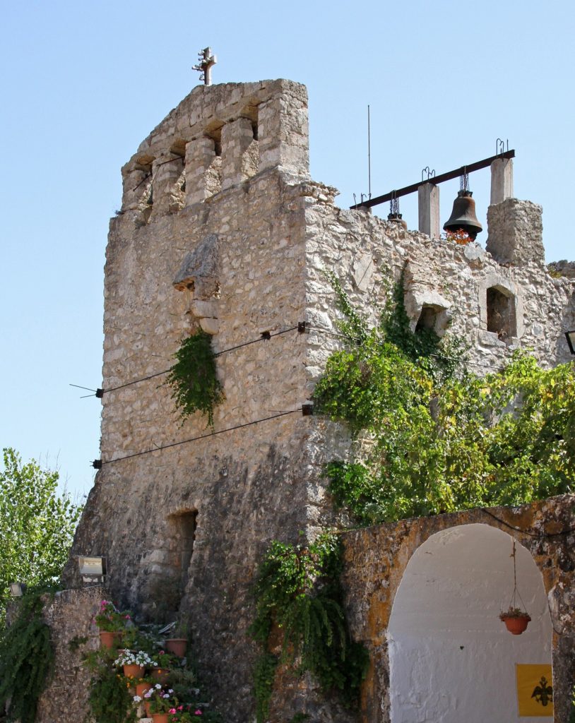 Hoher Wehrturm aus Bruchstein mit Kreuz und Glocke am Kloster Anafonitria