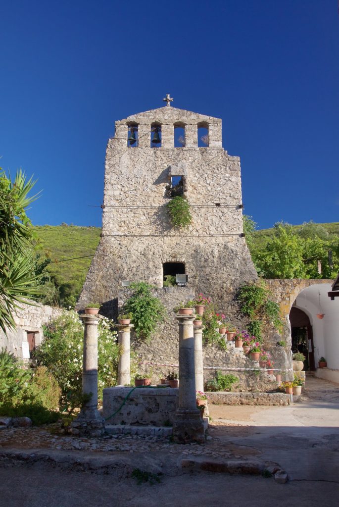 Steinerner Wehrturm mit Glockenöffnungen über dem Eingang des Klosters Anafonitria, davor alte Säulen