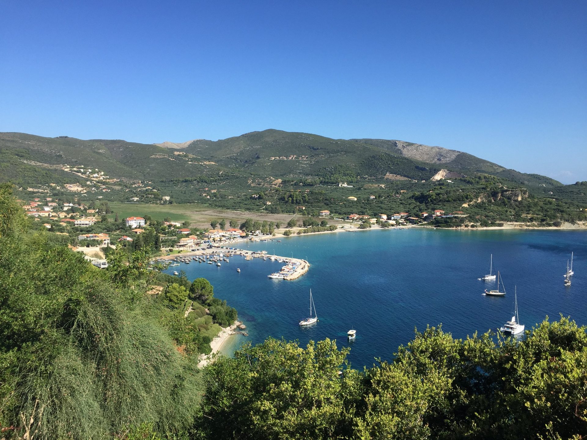 Die Bucht von Limni Keri mit Hafen, Booten und dem Tal dahinter, von oben gesehen