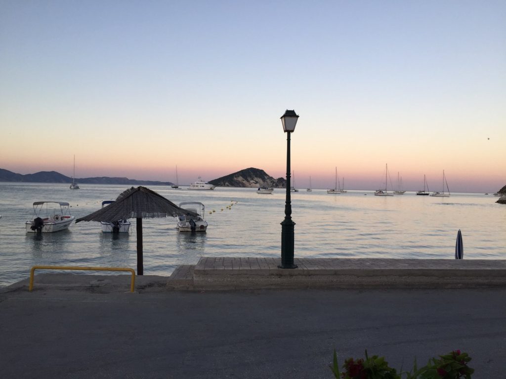 Strandpromenade von Limni Keri in der Abenddämmerung mit Laterne und Strohschirm