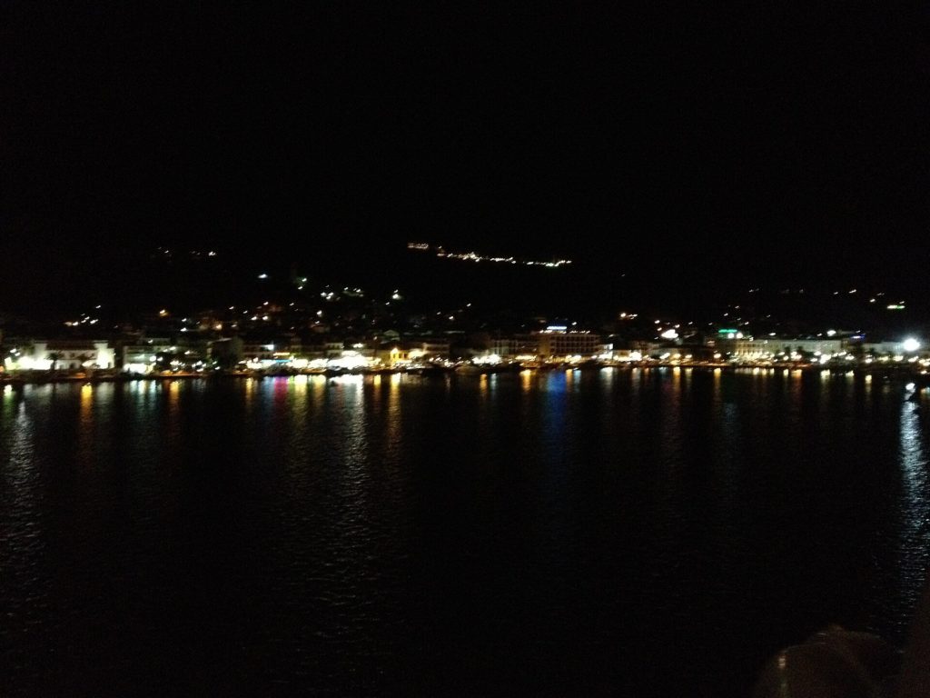 Beleuchtete Uferpromenade von Zakynthos-Stadt bei Nacht, die Lichter spiegeln sich im Hafenbecken