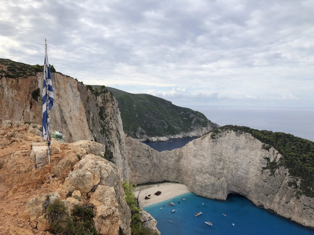 Griechische Flagge am Aussichtspunkt hoch über der Bucht von Navagio