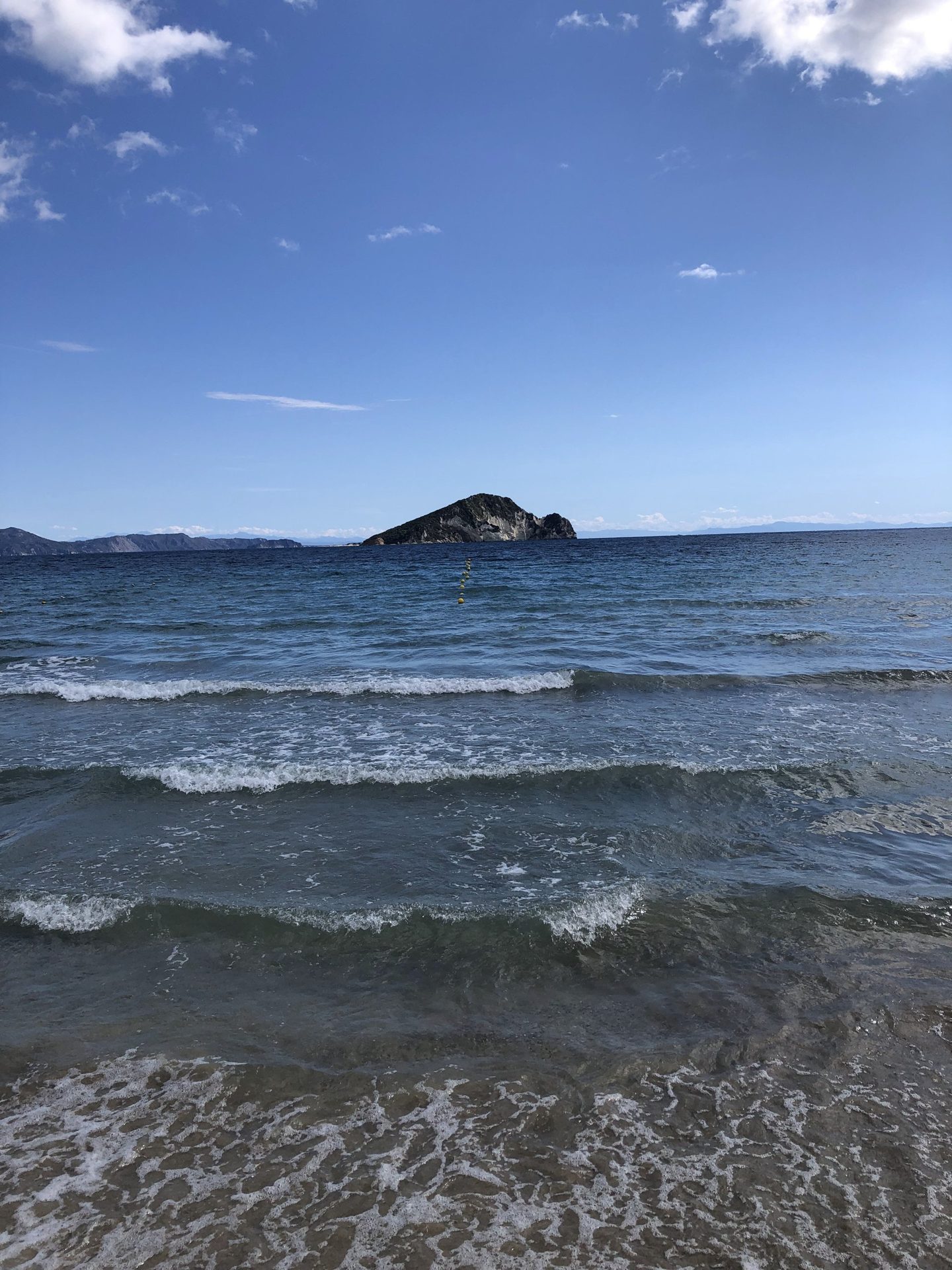 Wellen am Strand, im Hintergrund Marathonisi, September
