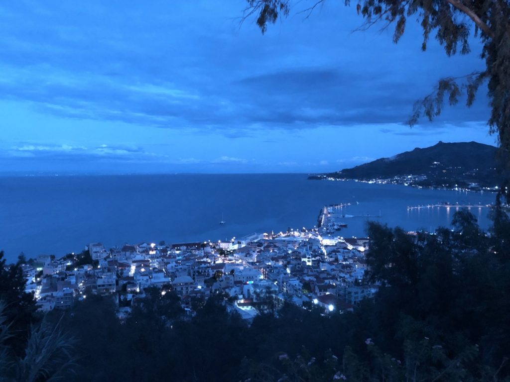 Zakynthos-Stadt in der Abenddämmerung von oben, dahinter die Küste