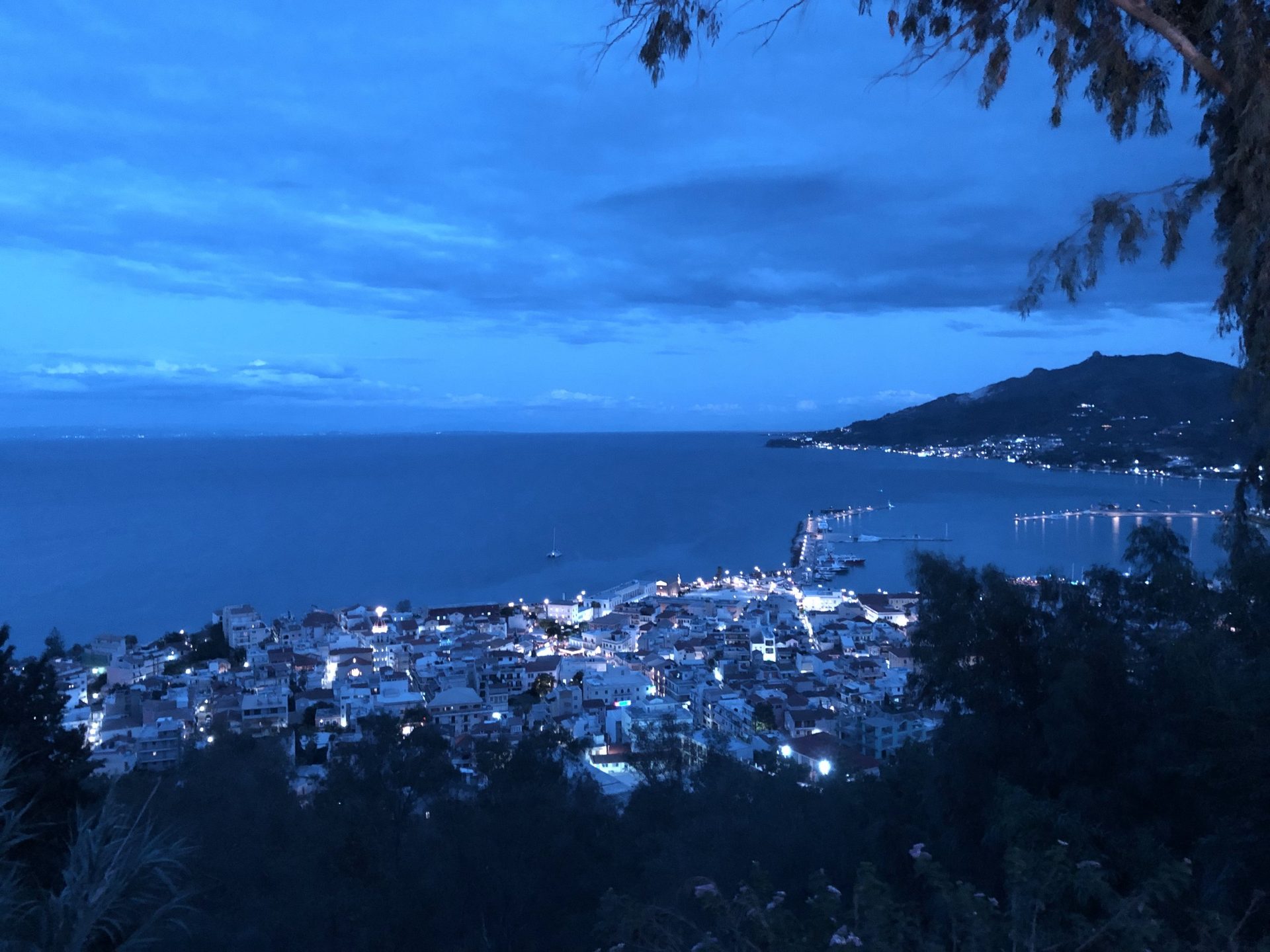 Zakynthos-Stadt in der Abenddämmerung von oben, dahinter die Küste